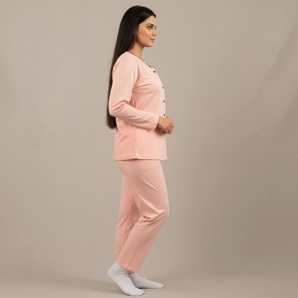 Woman wearing a pink pajama set against a beige background