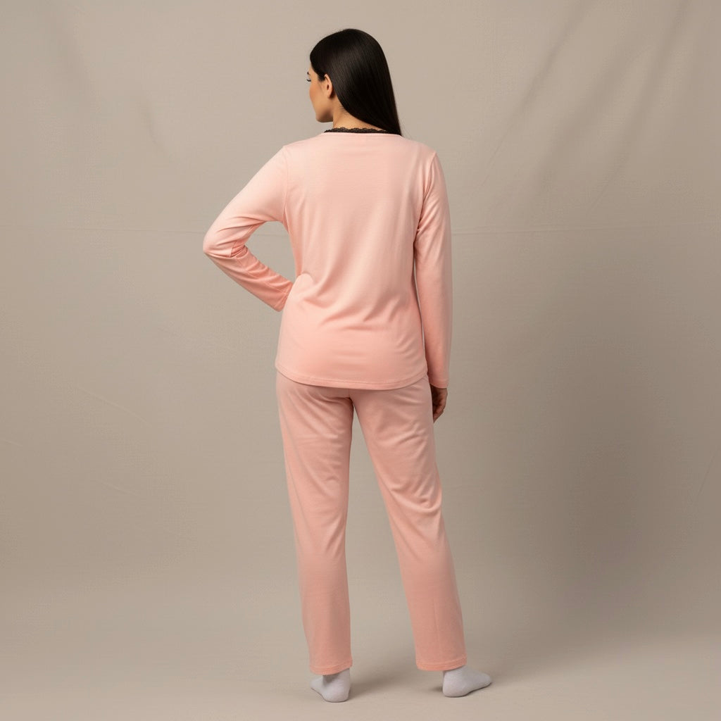 Person wearing a pink pajama set against a beige background