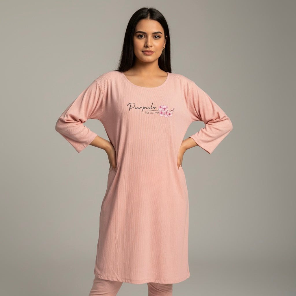 Woman wearing a pink nightshirt with a brand logo on a gray background