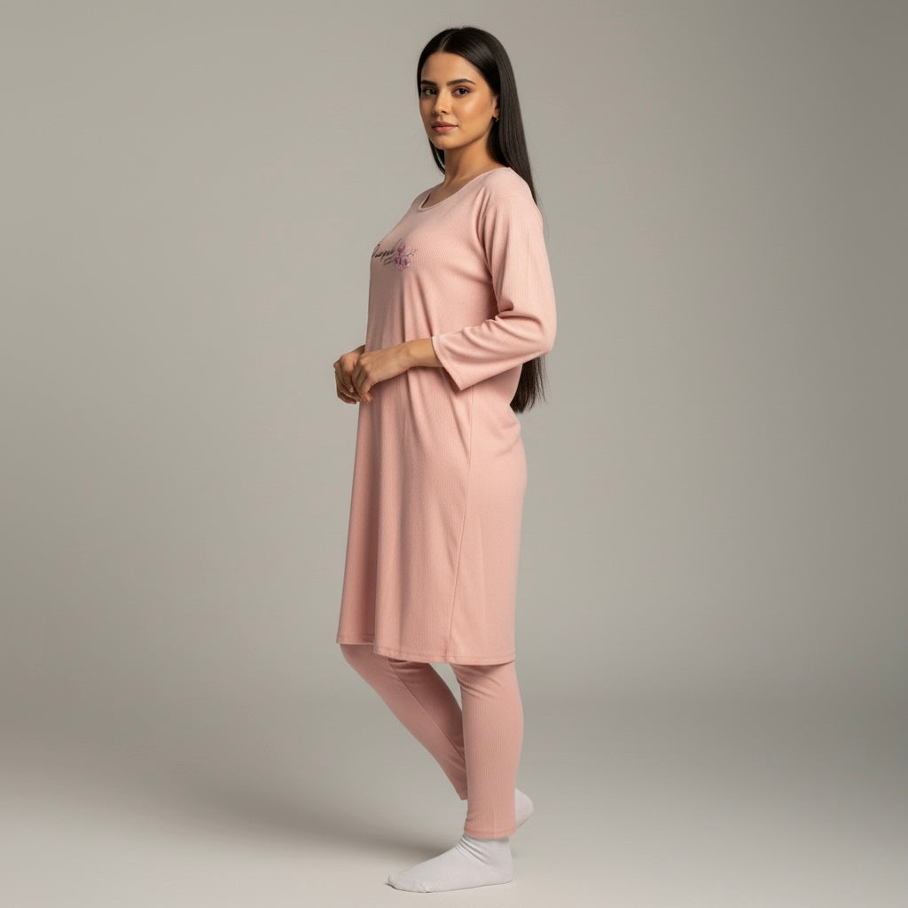 Woman wearing a pink pajama set against a plain background