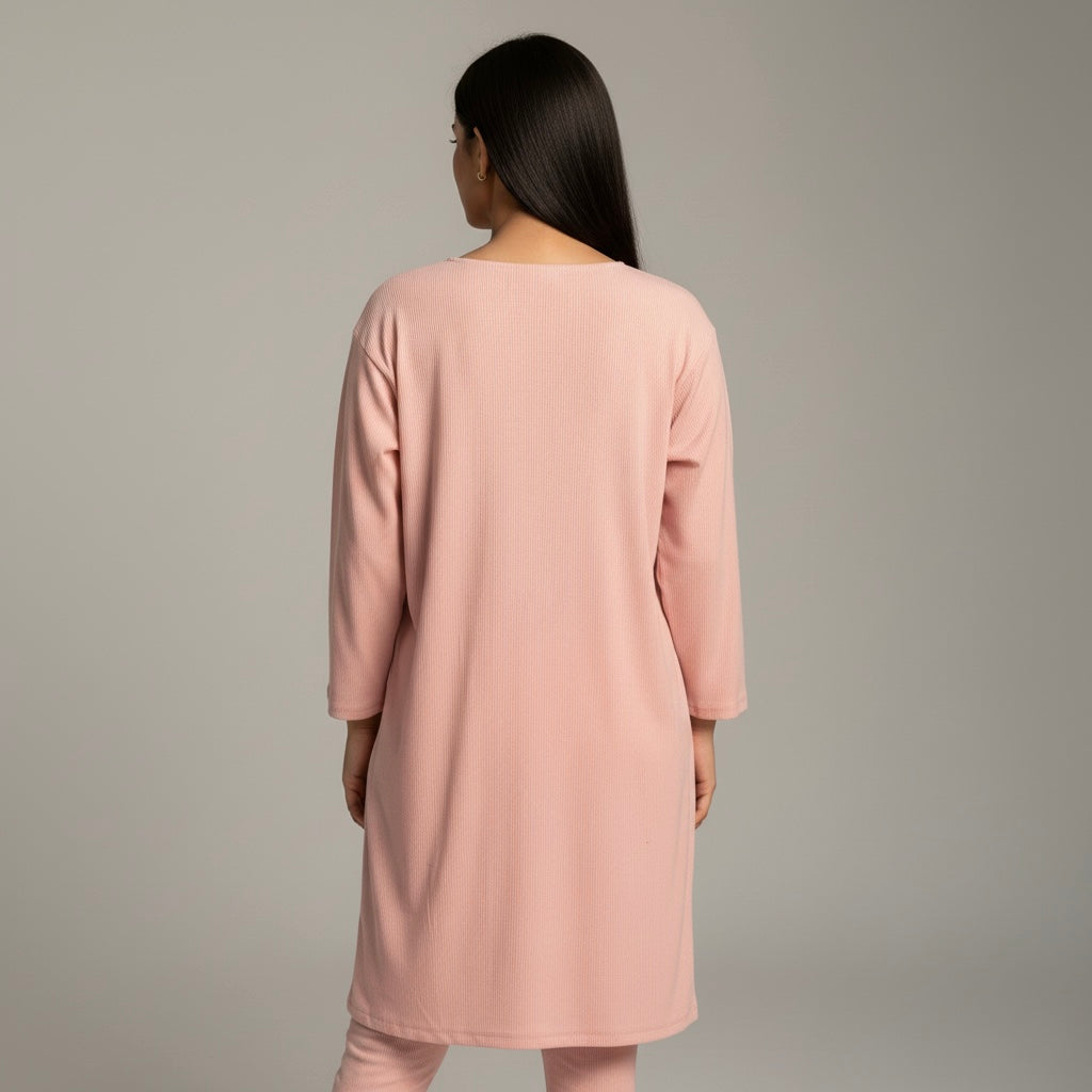Person wearing a pink dress against a gray background