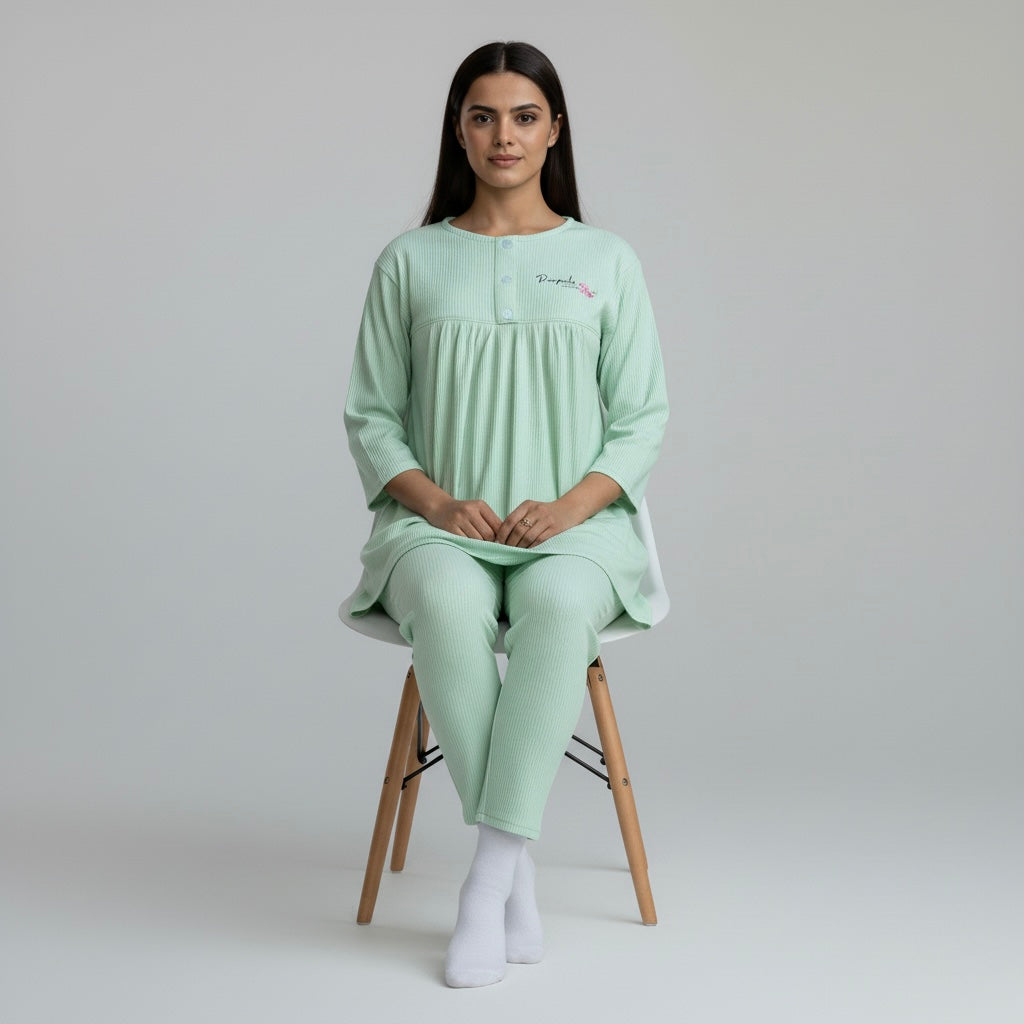 Woman wearing a light green pajama set sitting on a chair