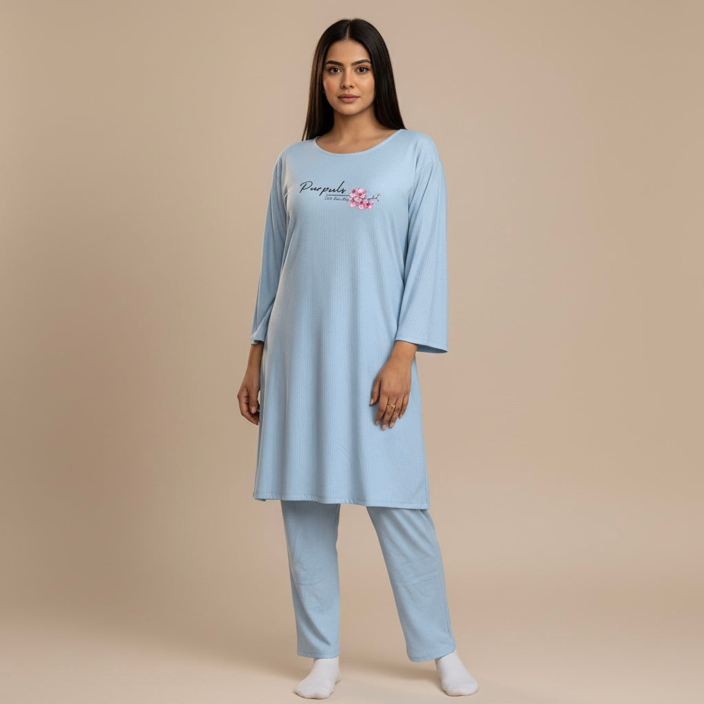 Woman wearing a light blue pajama set with a brand logo on a beige background
