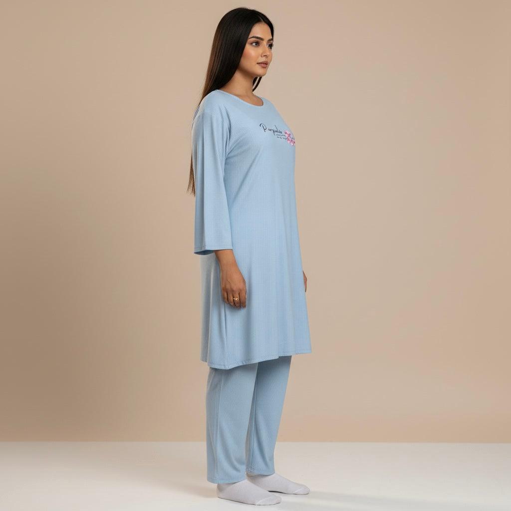 Woman wearing a light blue pajama set against a beige background