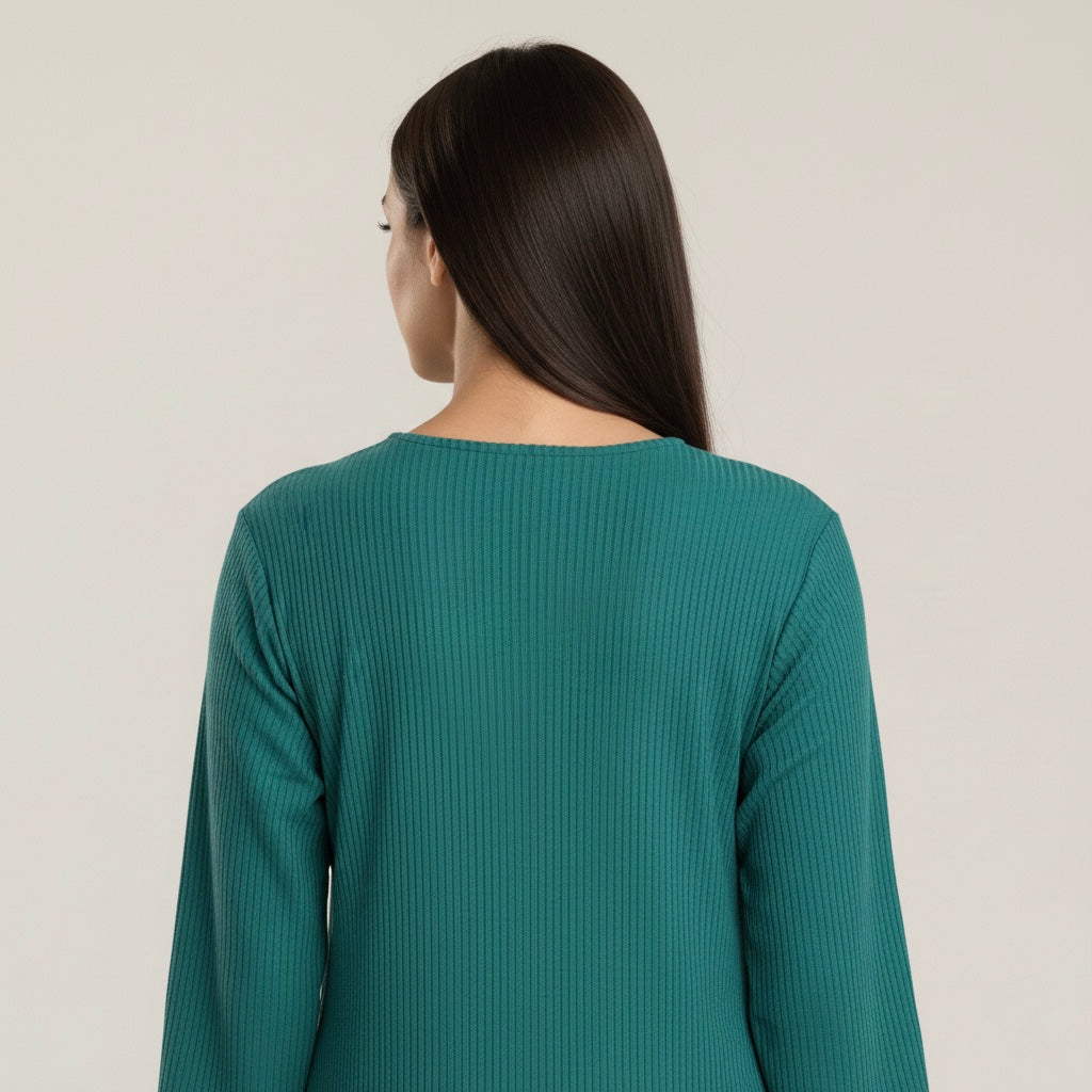 Woman wearing a teal ribbed sweater against a plain background