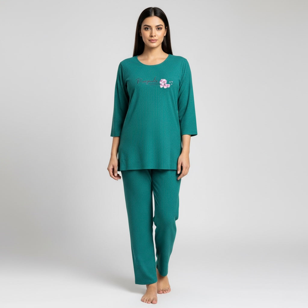 Woman wearing a teal pajama set with a small design on a light gray background