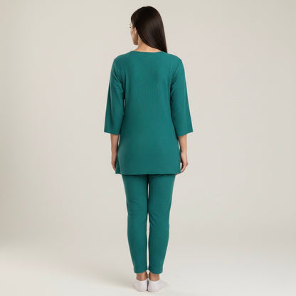 Woman wearing a teal outfit on a plain background