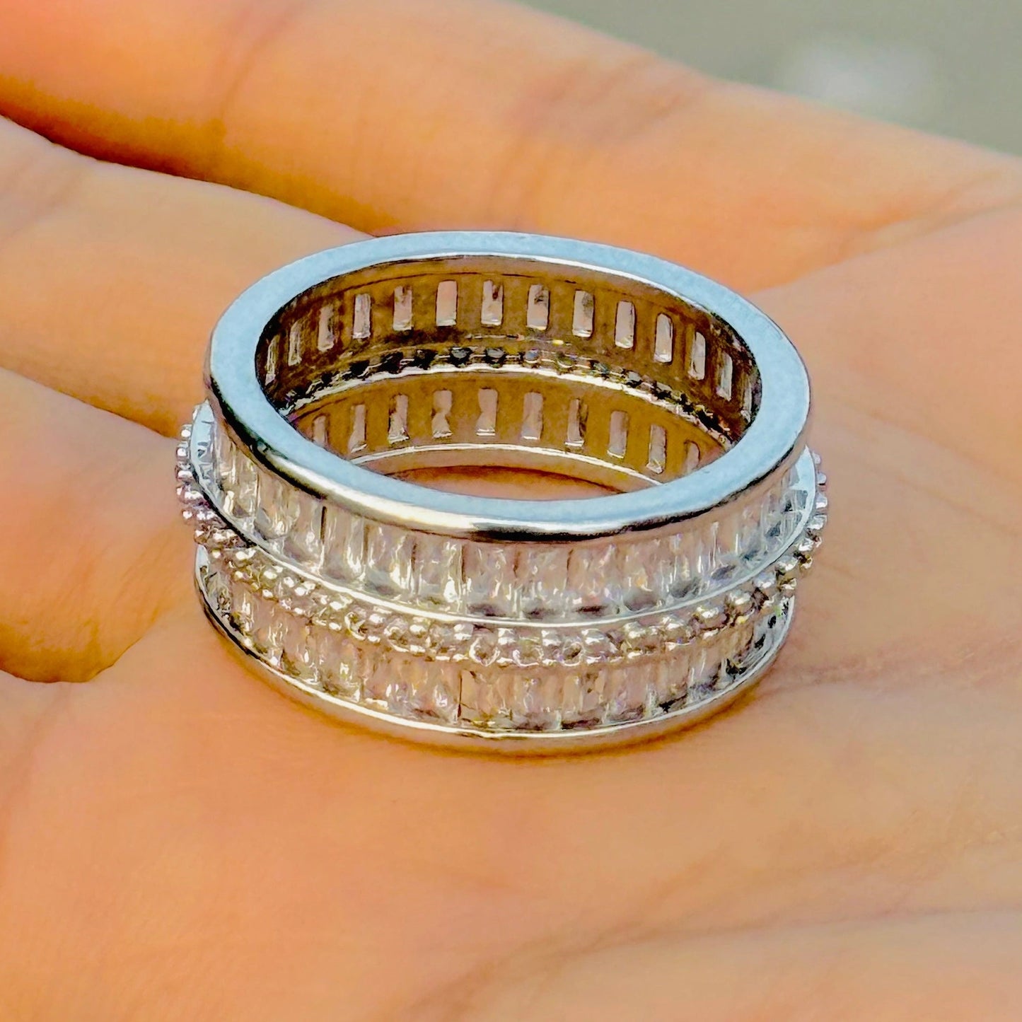 Silver ring with diamond accents on a hand