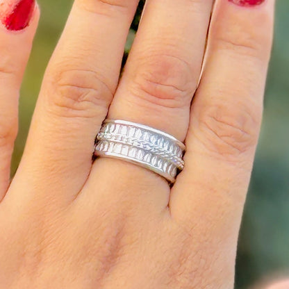 Silver ring on a finger with a blurred green background