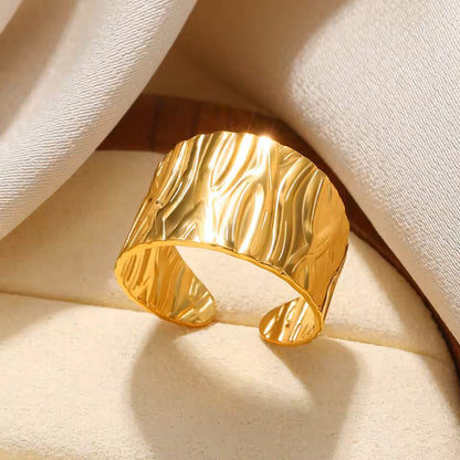 Gold cuff bracelet on a beige fabric background