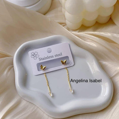 Gold butterfly earrings on a white dish with 'Angelina Isabel' branding.