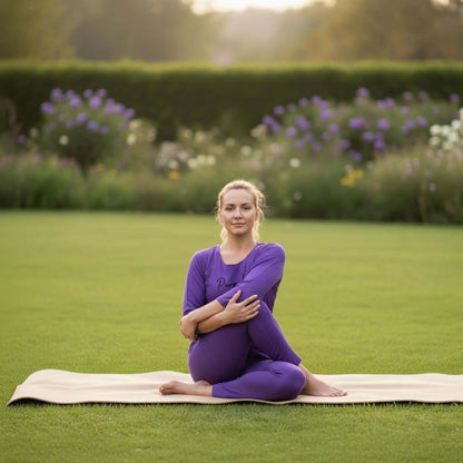 Woman in purple stretchable yoga wear doing seated stretch on mat in garden