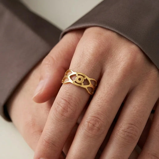 Gold ring on a person's finger with a neutral background
