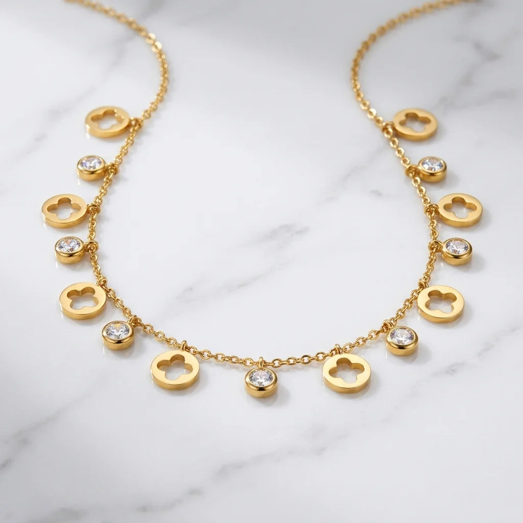 Gold necklace with heart-shaped pendants on a marble surface