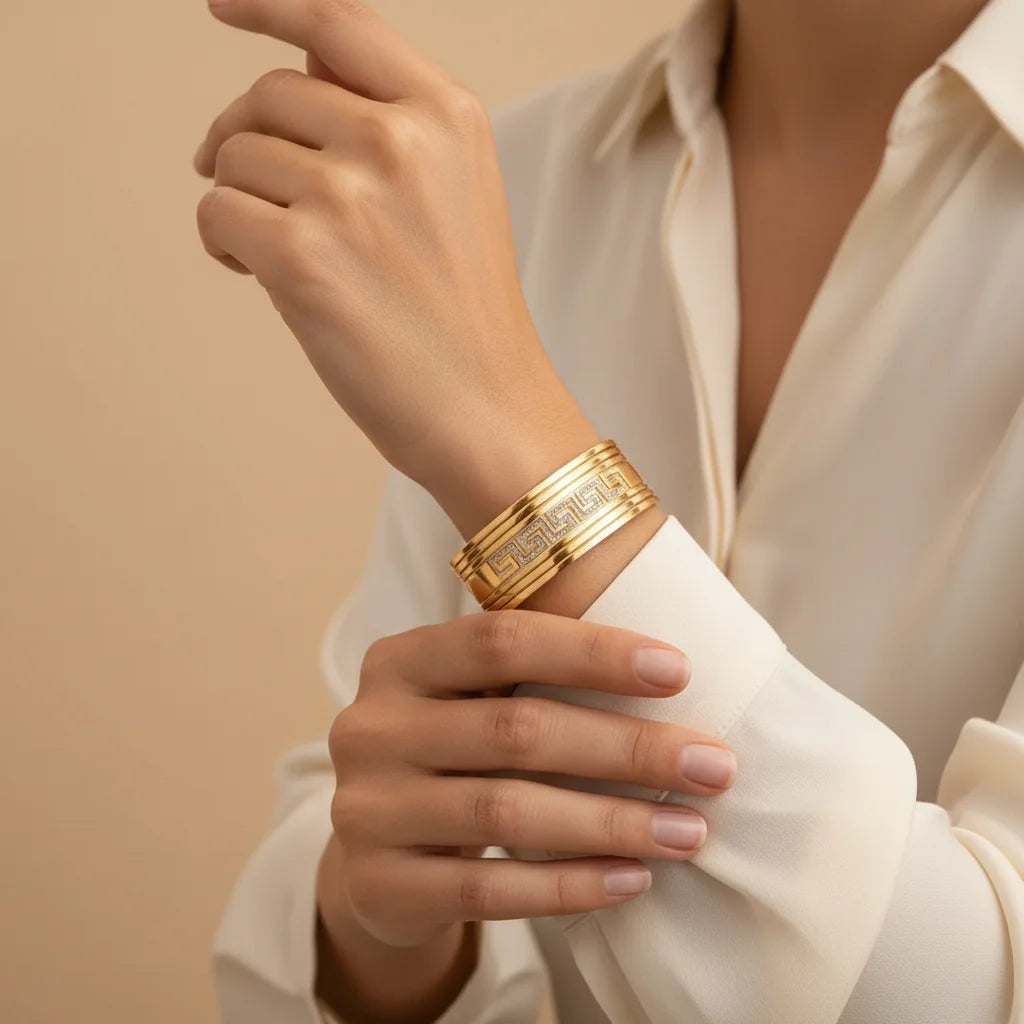 Gold bracelet on a wrist with a neutral background