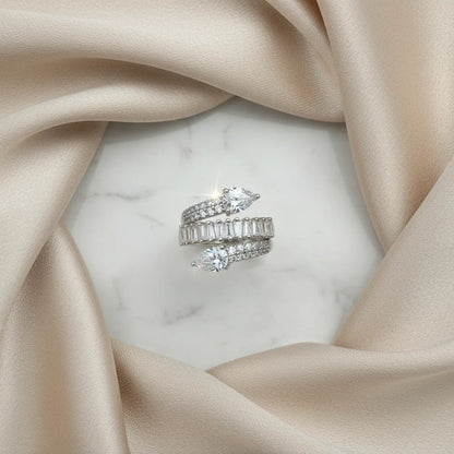 Two diamond rings on a marble surface with beige fabric