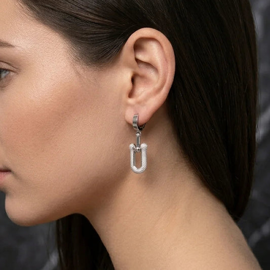 Close-up of a woman wearing a silver earring with a dark background
