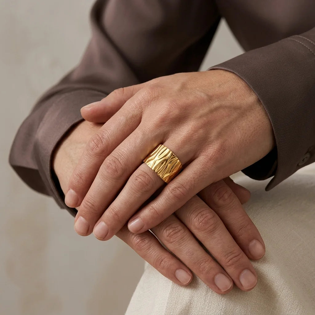 Close-up of hands with a gold ring on a neutral background