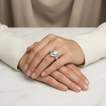 Close-up of a hand wearing a diamond ring on a neutral background