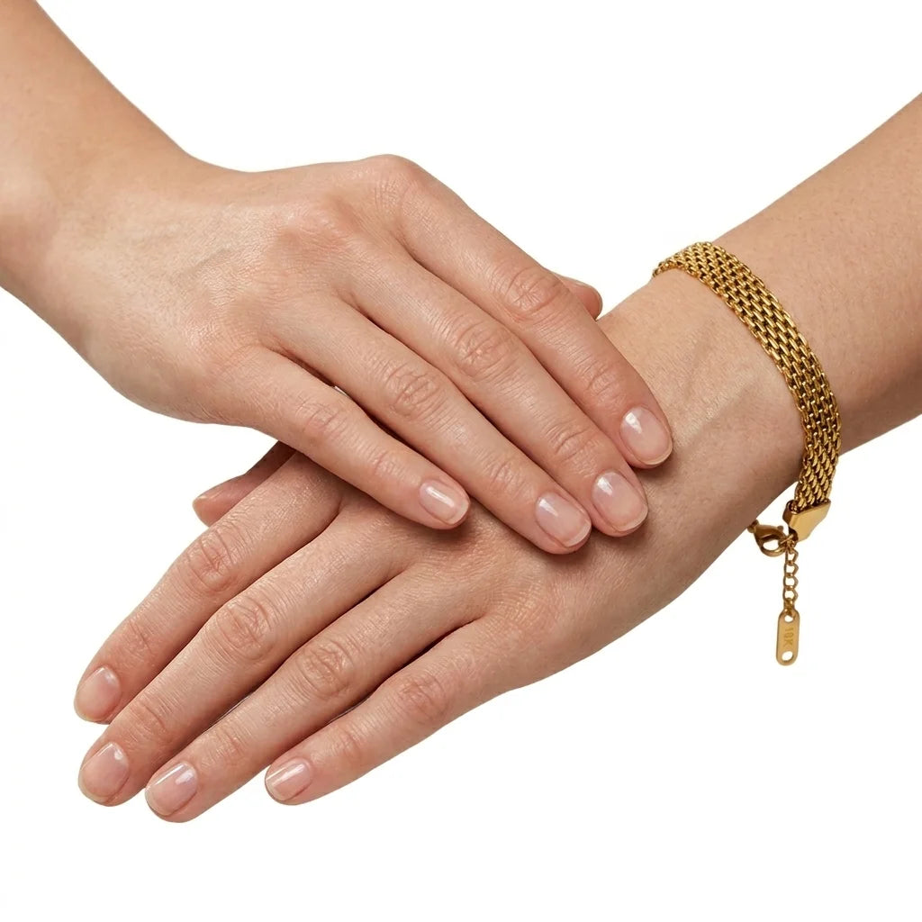 Close-up of hands with a gold bracelet on a white background