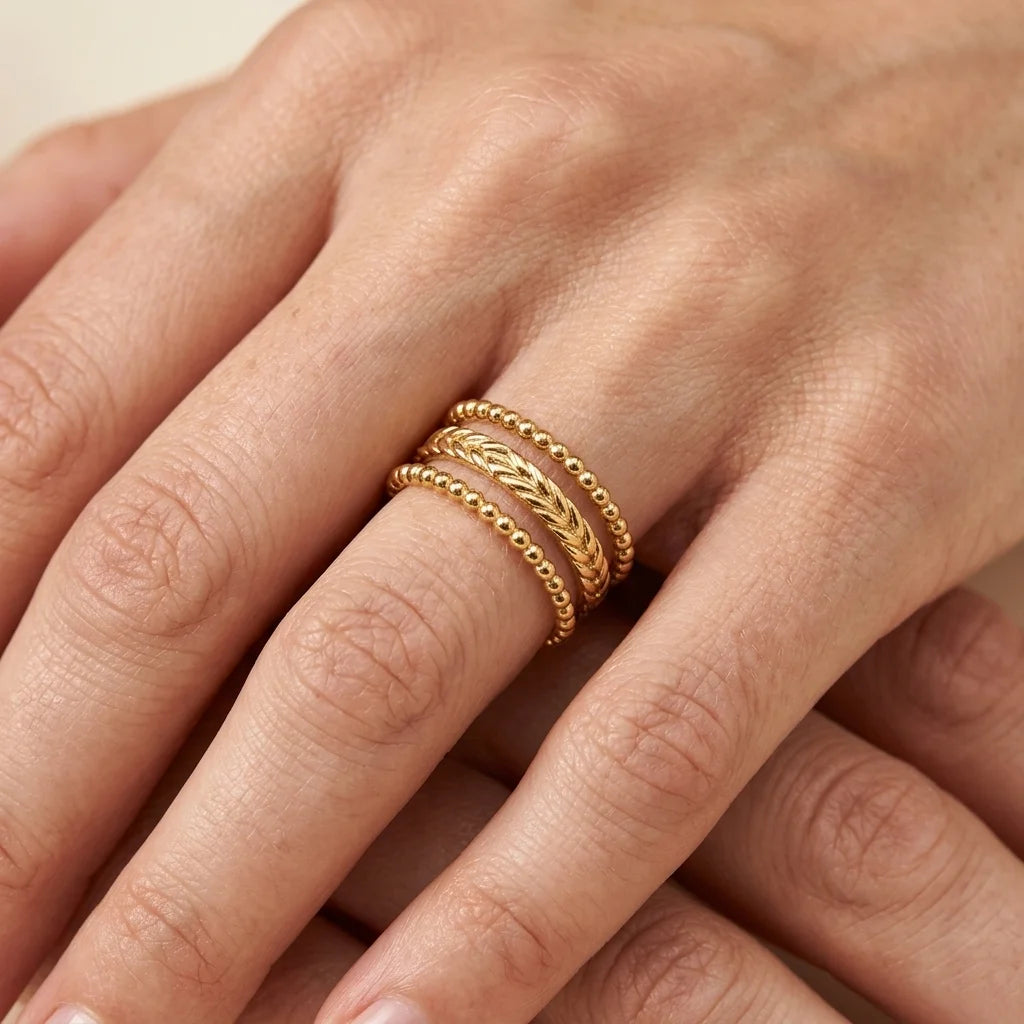 Gold ring on a person's finger with a neutral background