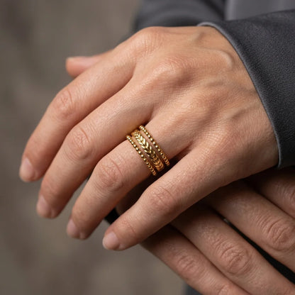 Close-up of a hand wearing a gold ring with a blurred background