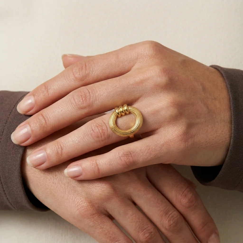 Gold ring on a hand against a neutral background