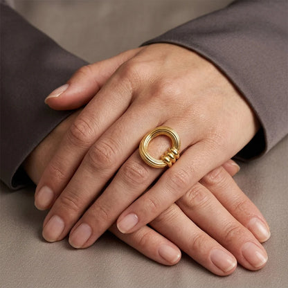Gold ring on a hand with a neutral background