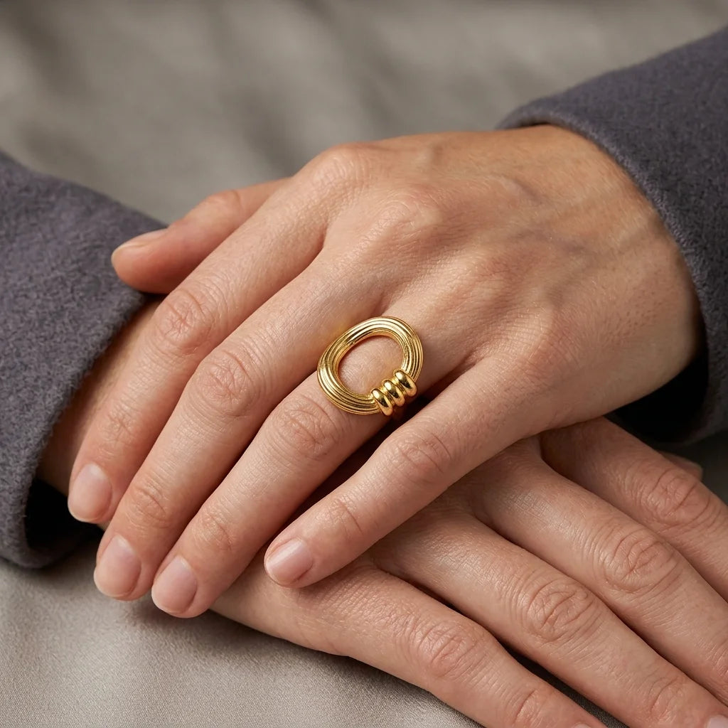 Gold ring on a hand with a neutral background