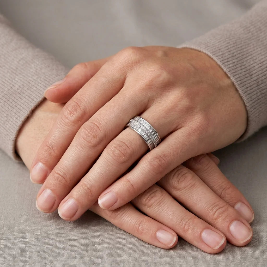 Close-up of hands with a silver ring on a neutral background