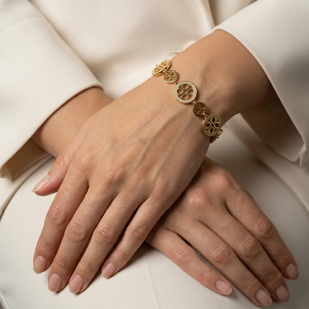 Gold bracelet on a wrist with a neutral background