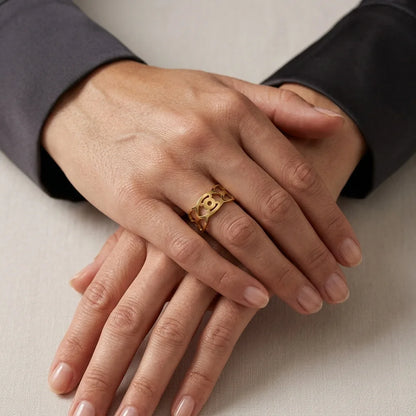 Close-up of hands with a gold ring on a neutral background