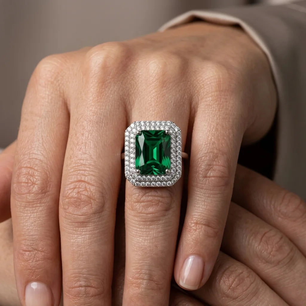 Close-up of a hand wearing a green gemstone ring with a silver band.