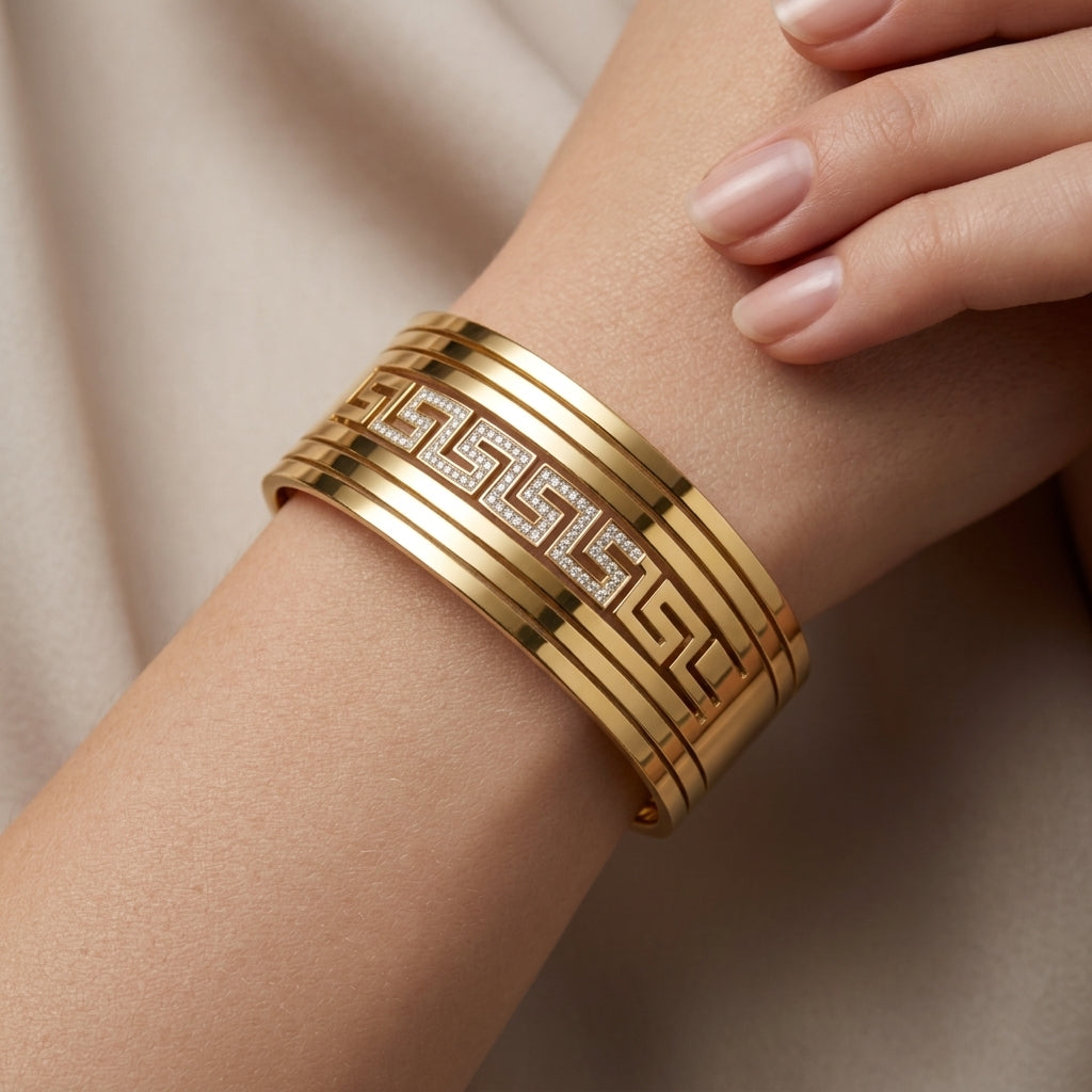 Gold bracelet on a wrist with a neutral background