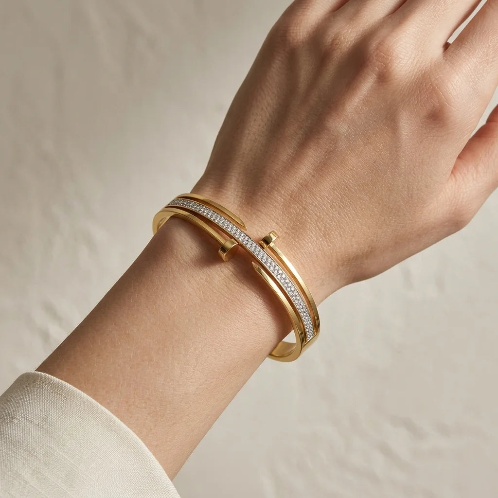 Gold bracelet with diamonds on a wrist against a neutral background