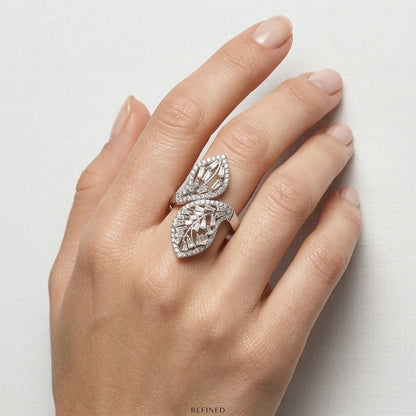 Hand wearing a decorative diamond ring on a light background