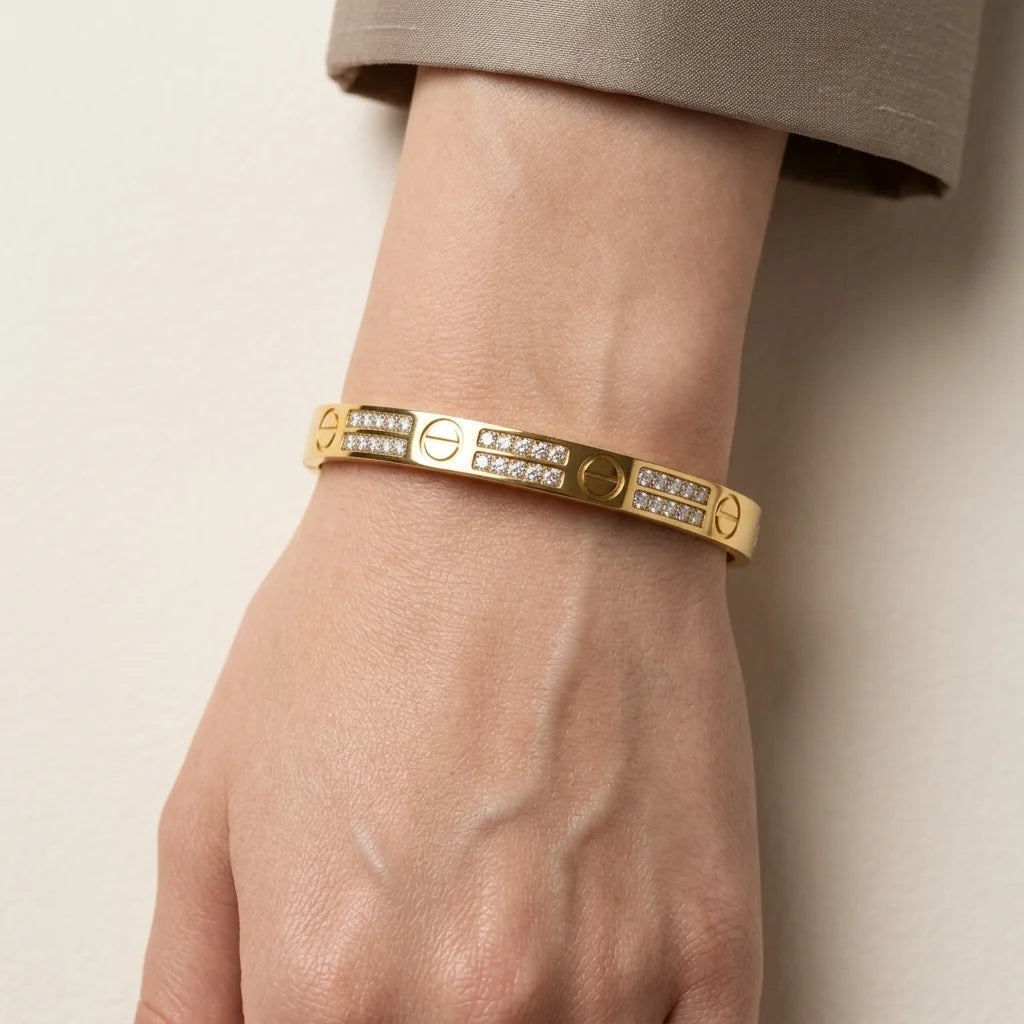 Gold bracelet with diamond accents on a wrist against a neutral background