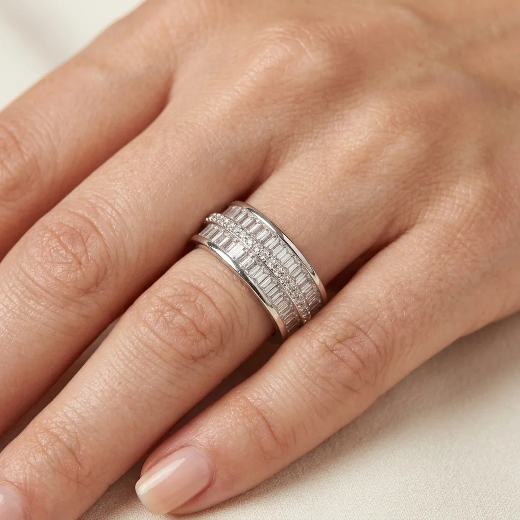 Silver ring on a person's finger against a neutral background