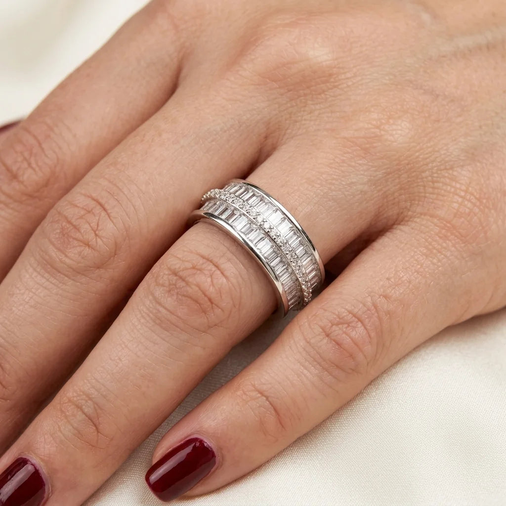 Close-up of a hand wearing a silver ring with a white background