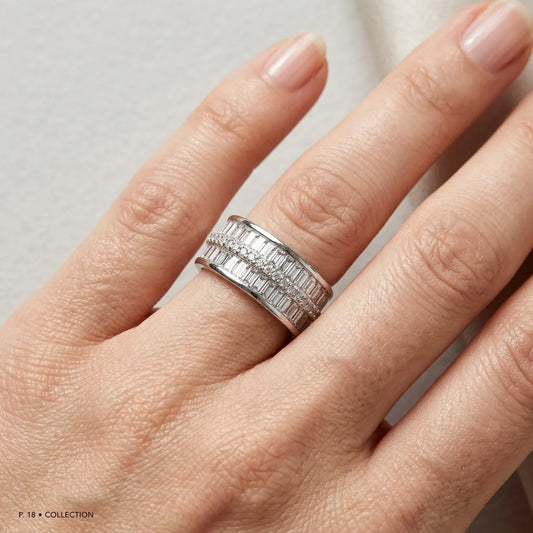 Silver ring on a person's finger against a neutral background