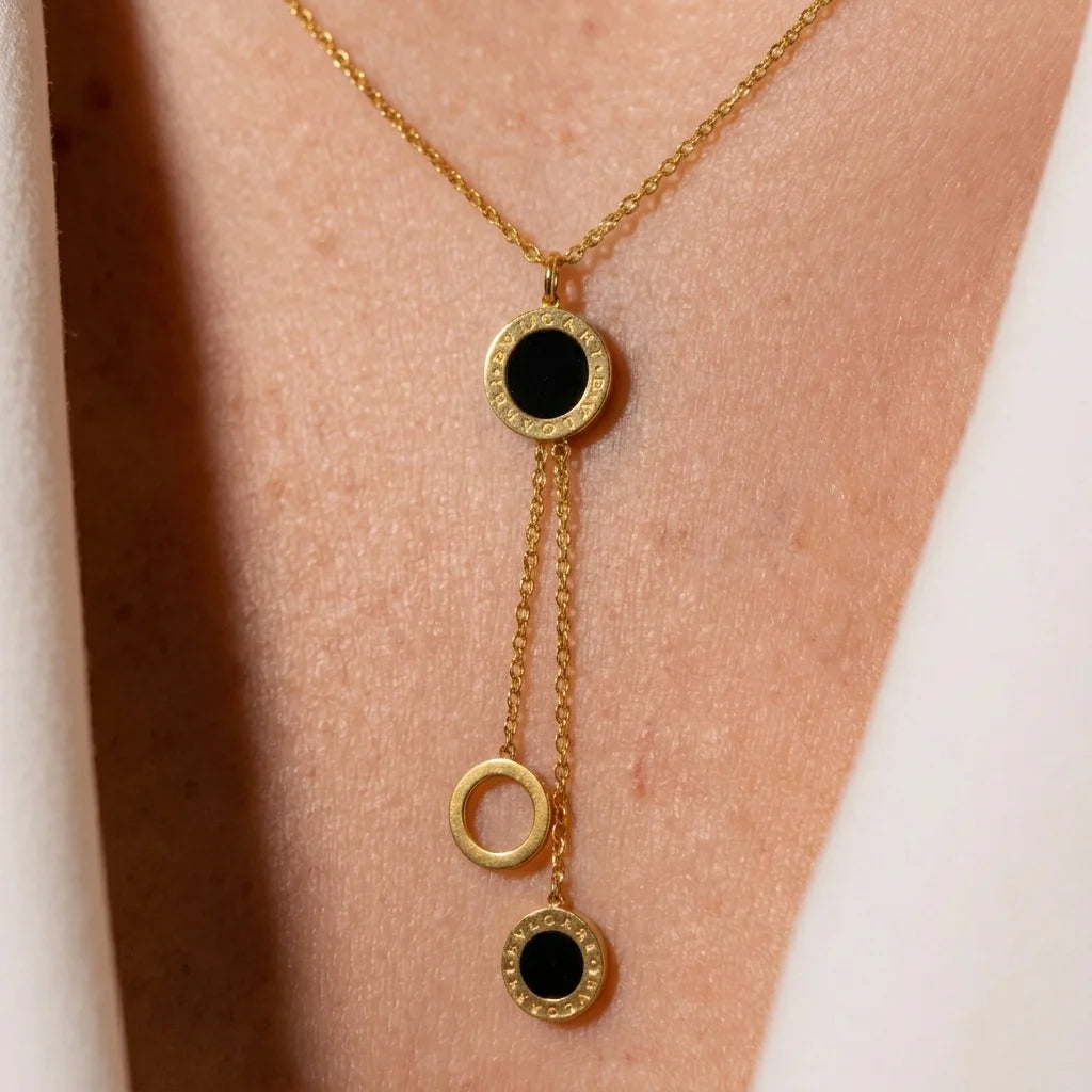 Gold necklace with black stones on a person's neck