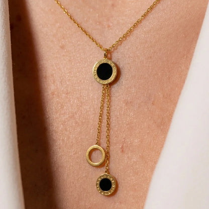 Gold necklace with black stones on a person's neck