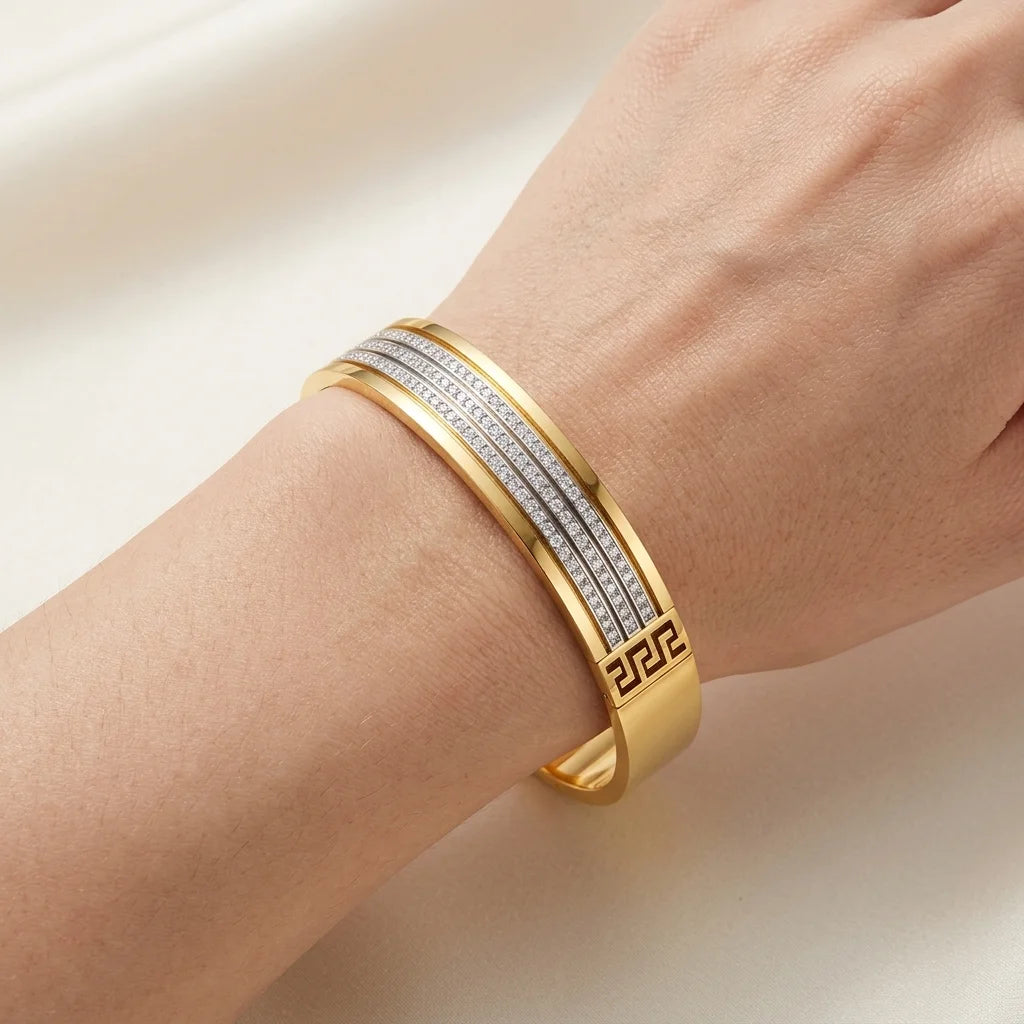 Gold bracelet with diamond accents on a wrist against a light background