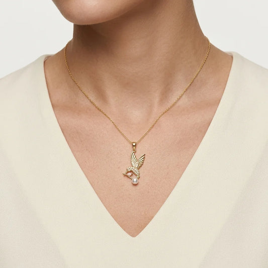 Gold necklace with a pendant worn by a person against a neutral background