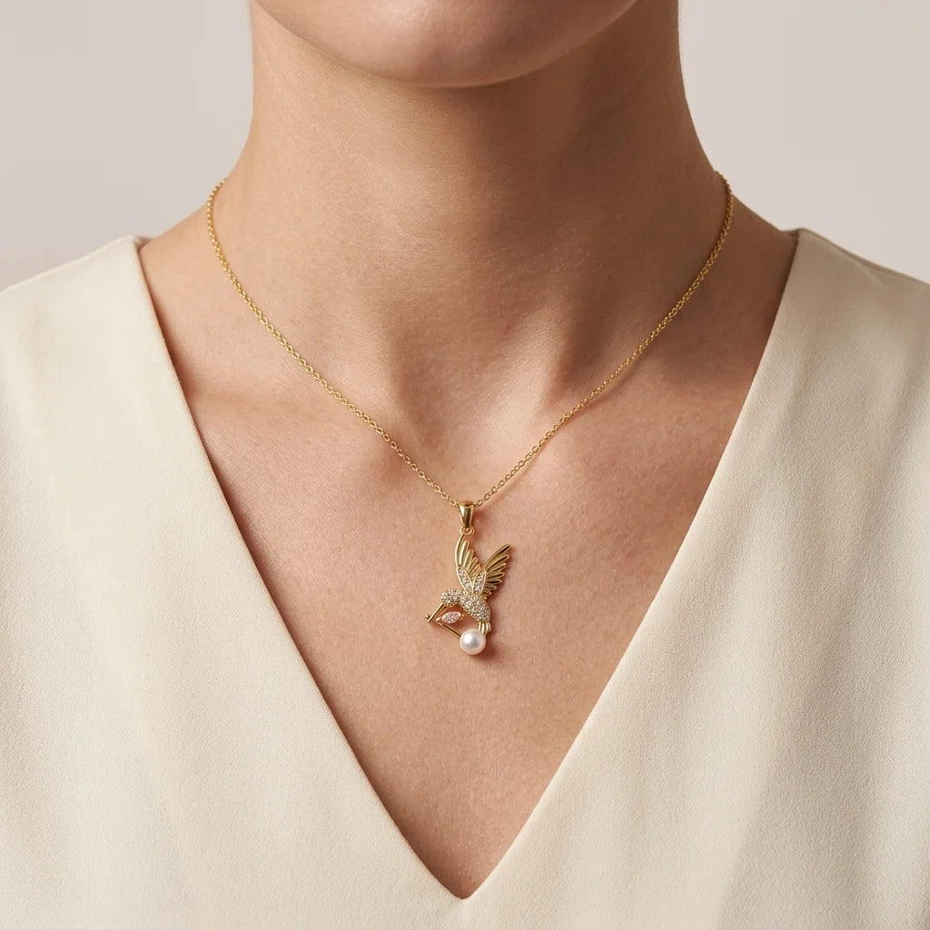 Gold necklace with a pendant worn by a person against a neutral background