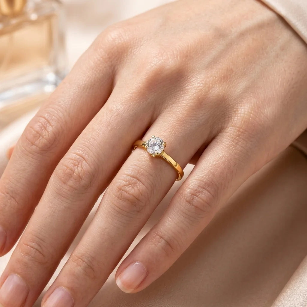 Gold ring with a diamond on a hand against a soft background