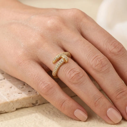 Gold ring on a person's finger with a neutral background