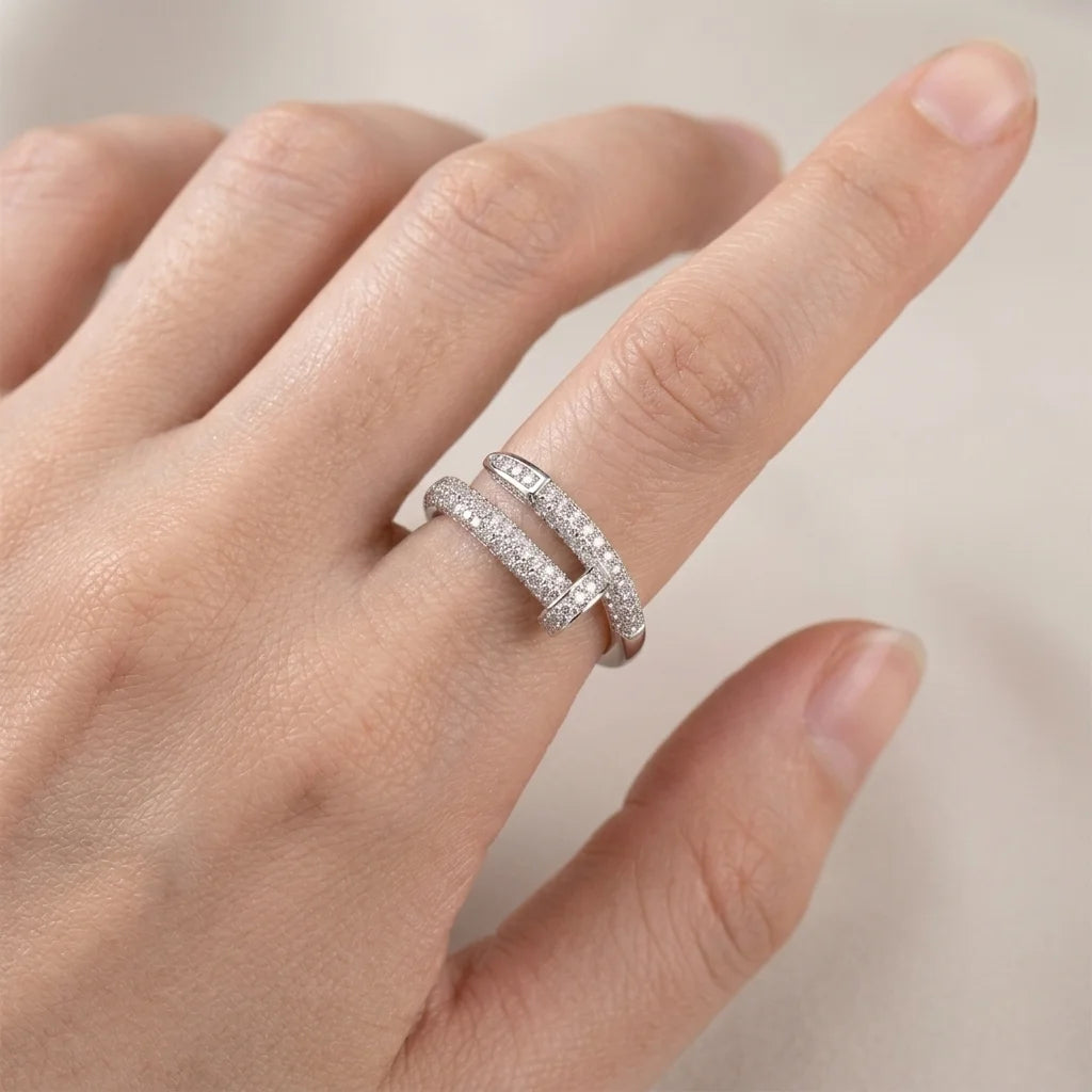 Hand wearing a silver ring with a blurred background