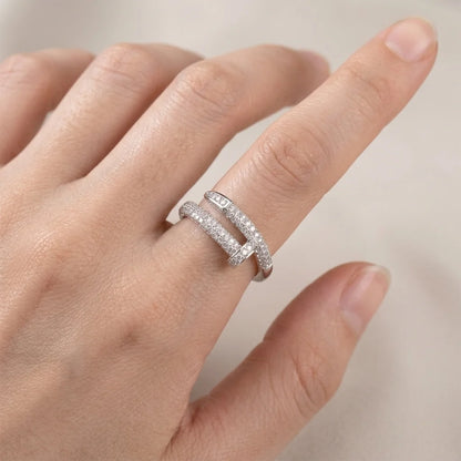 Hand wearing a silver ring with a blurred background