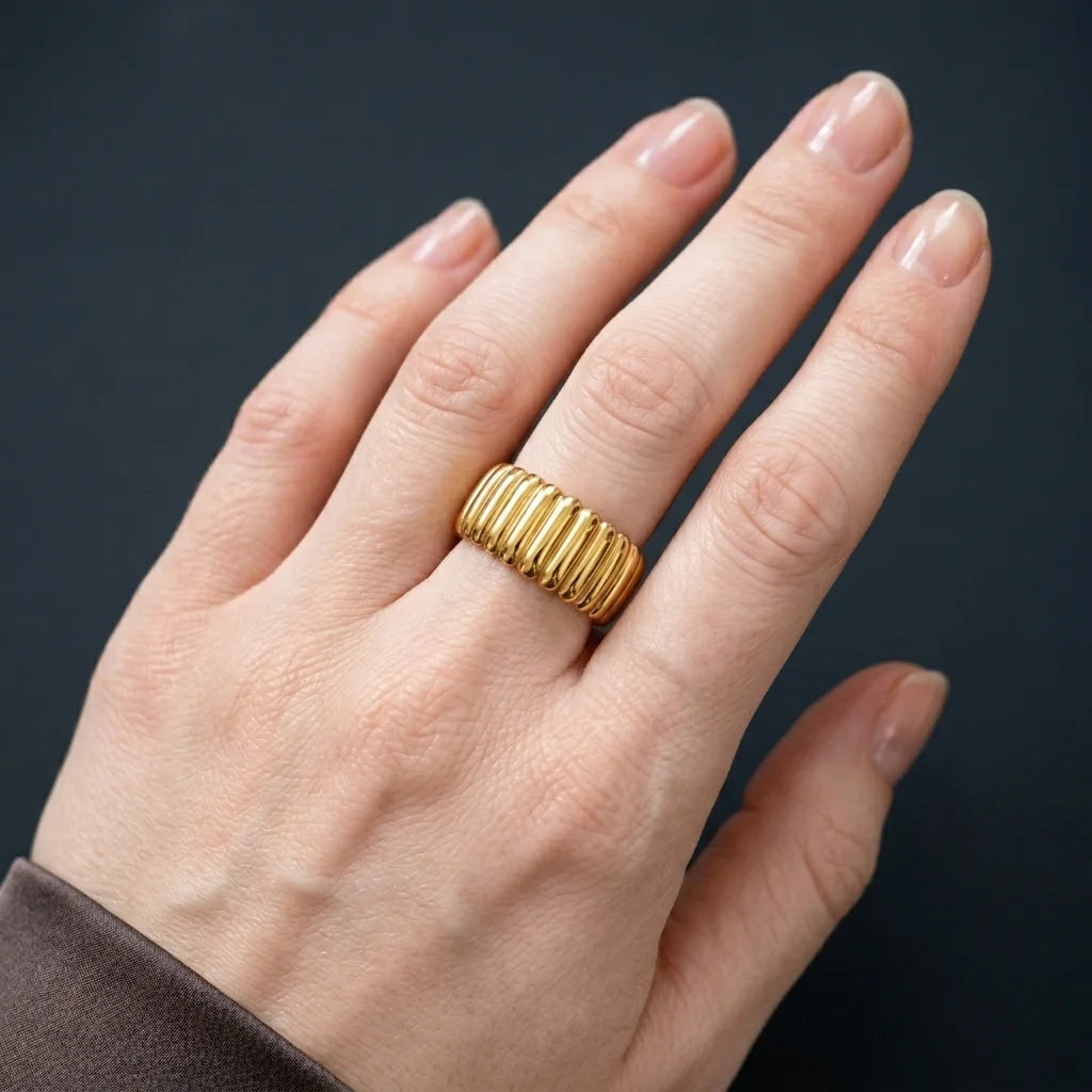 Gold ring on a hand against a dark background